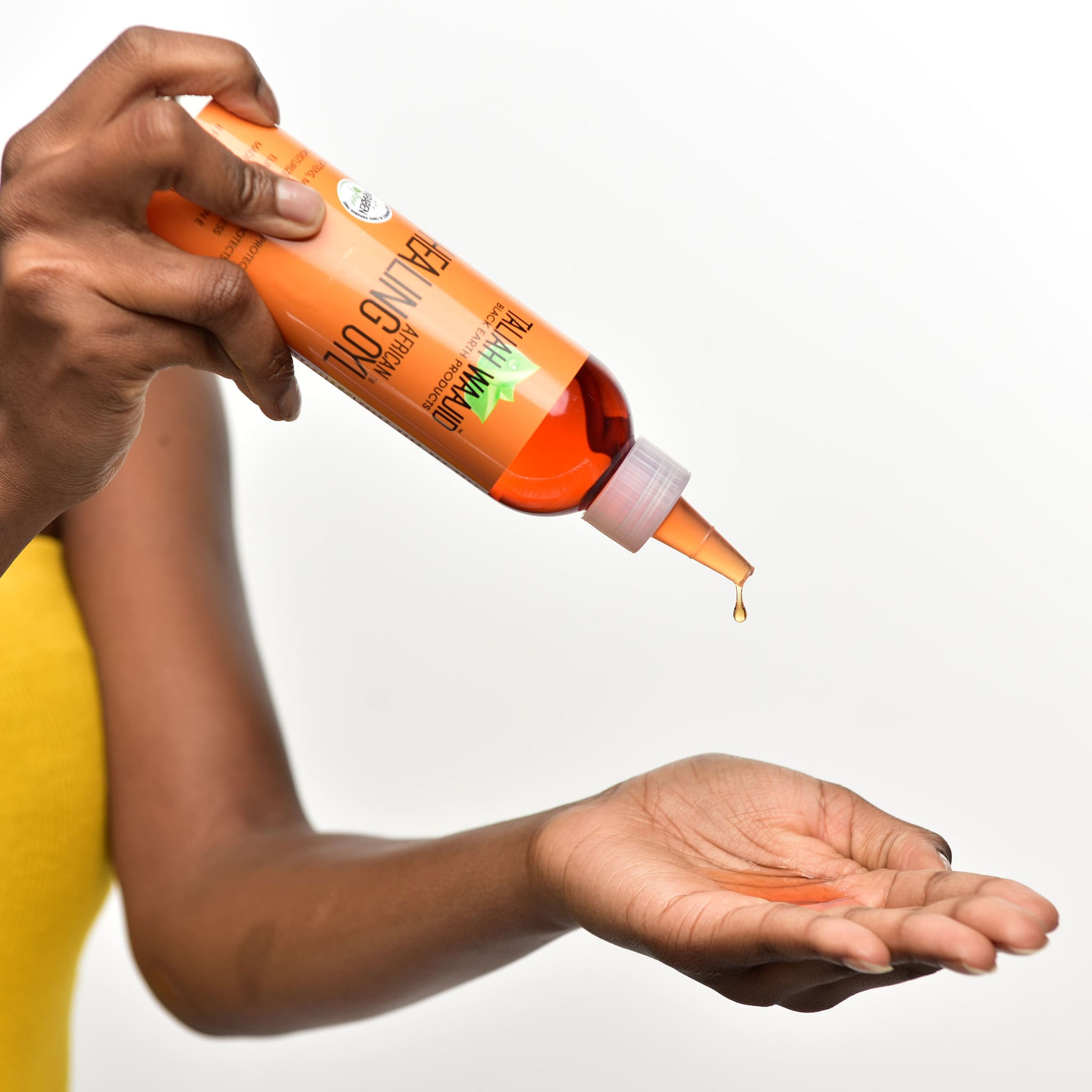 Woman pouring African Healing Oyl in her hand